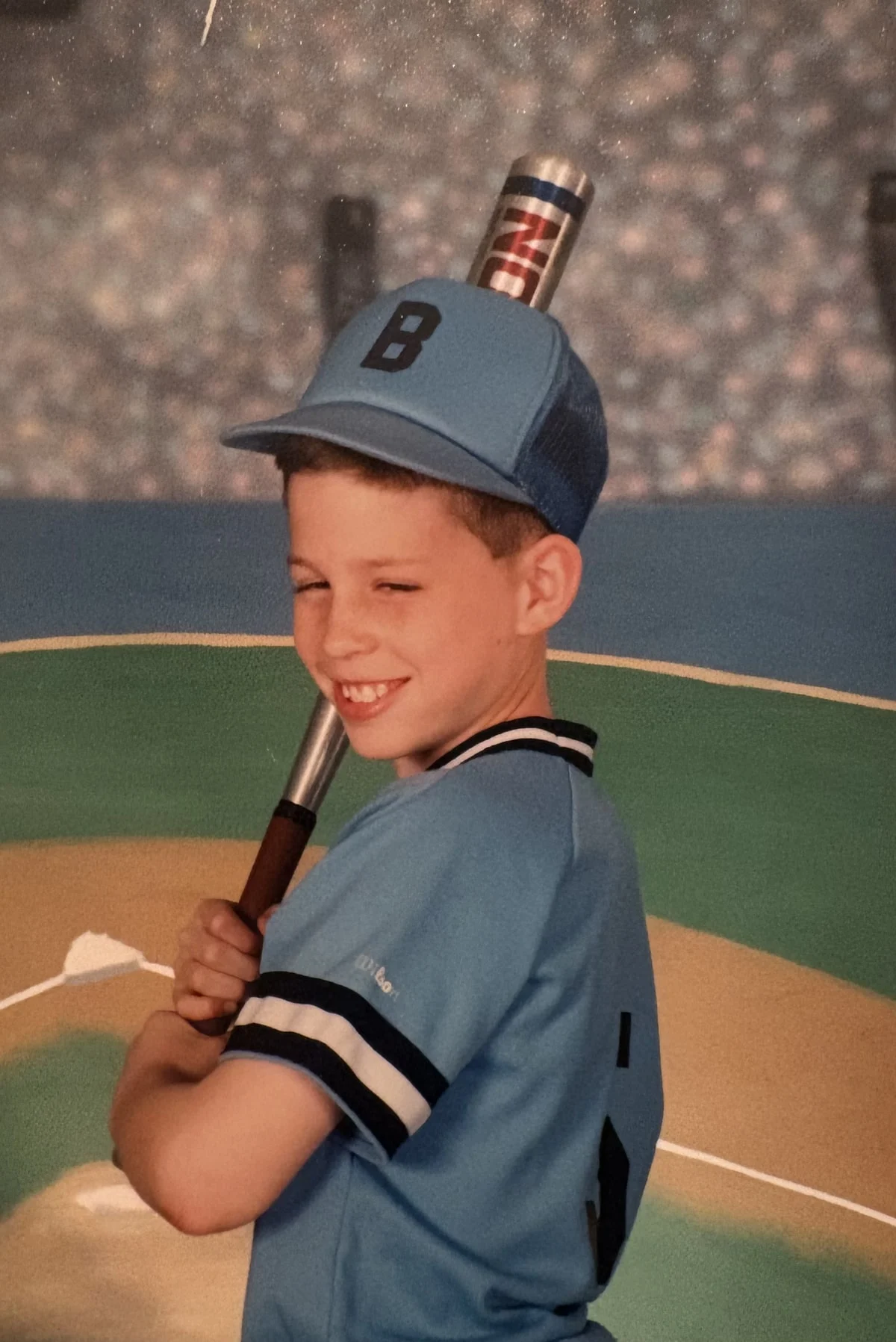 Dan Hogan in an Audubon Little League baseball uniform with a bat
