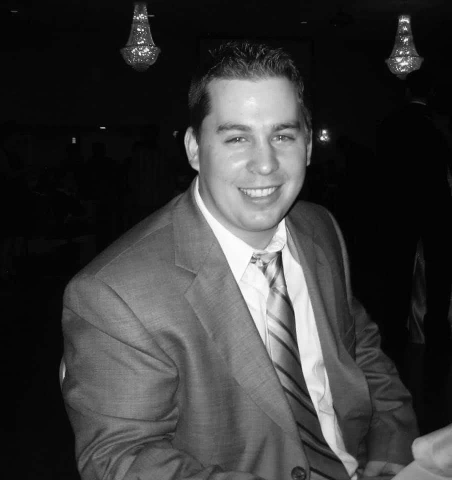 Dan Hogan smiling in a suit